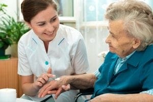 elderly woman with Parkinson's disease receiving assistance