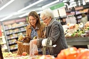 elderly woman out shopping with her in-home care agent who is helping with household chores and transporting her via car
