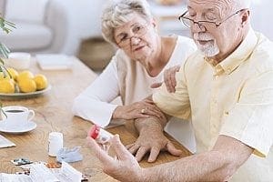 an elderly man about to take his medication as part of recovery care