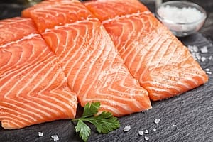 Fatty fish salmon steaks cut raw on board with salt