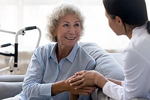 a woman who is receiving fall prevention help from an in-home caregiver