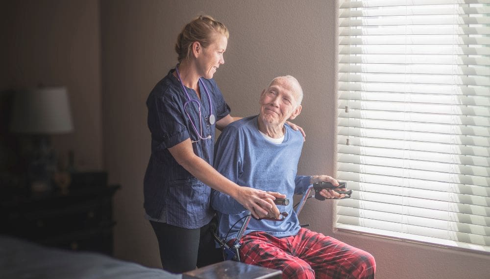 nurse helping senior with mobility issues at home